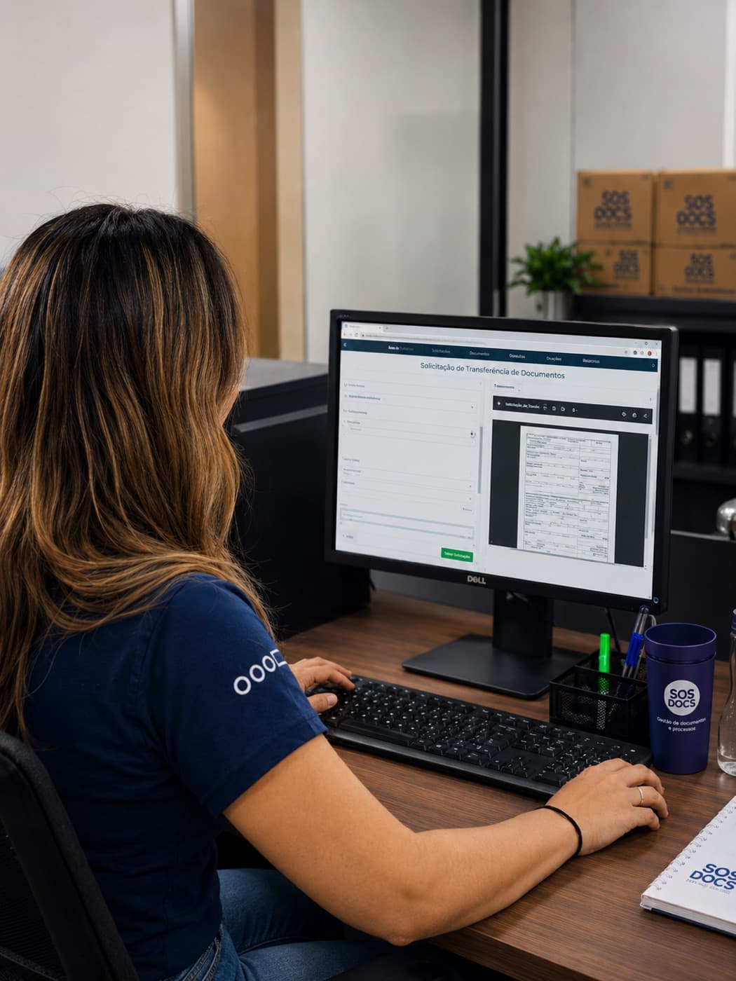 Analista da SOS Docs conferindo em tela a imagem digitalizada ao lado do formulário de solicitação, com as caixas do acervo já identificadas ao fundo